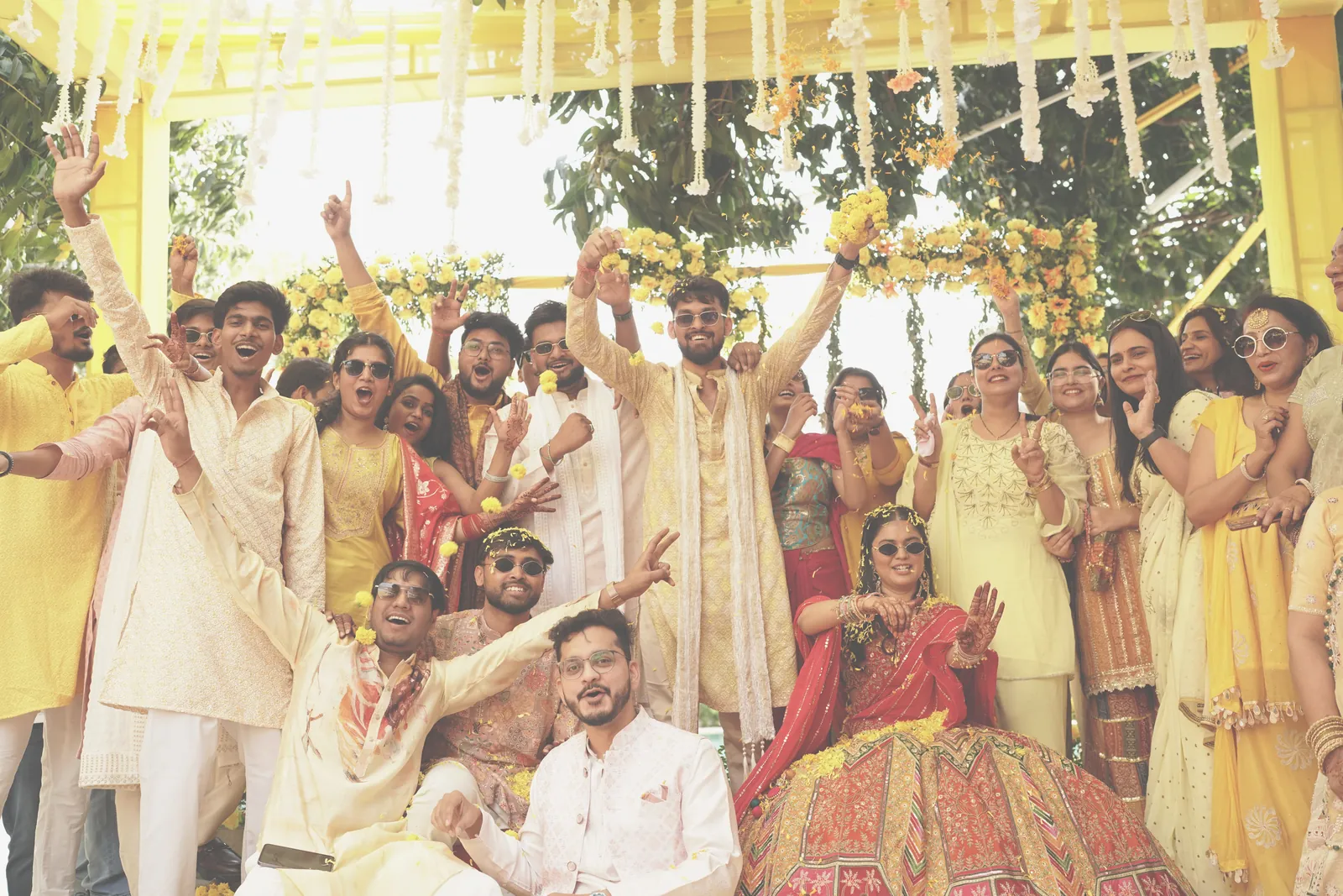 Friends in yellow cheering around the bride at her haldi