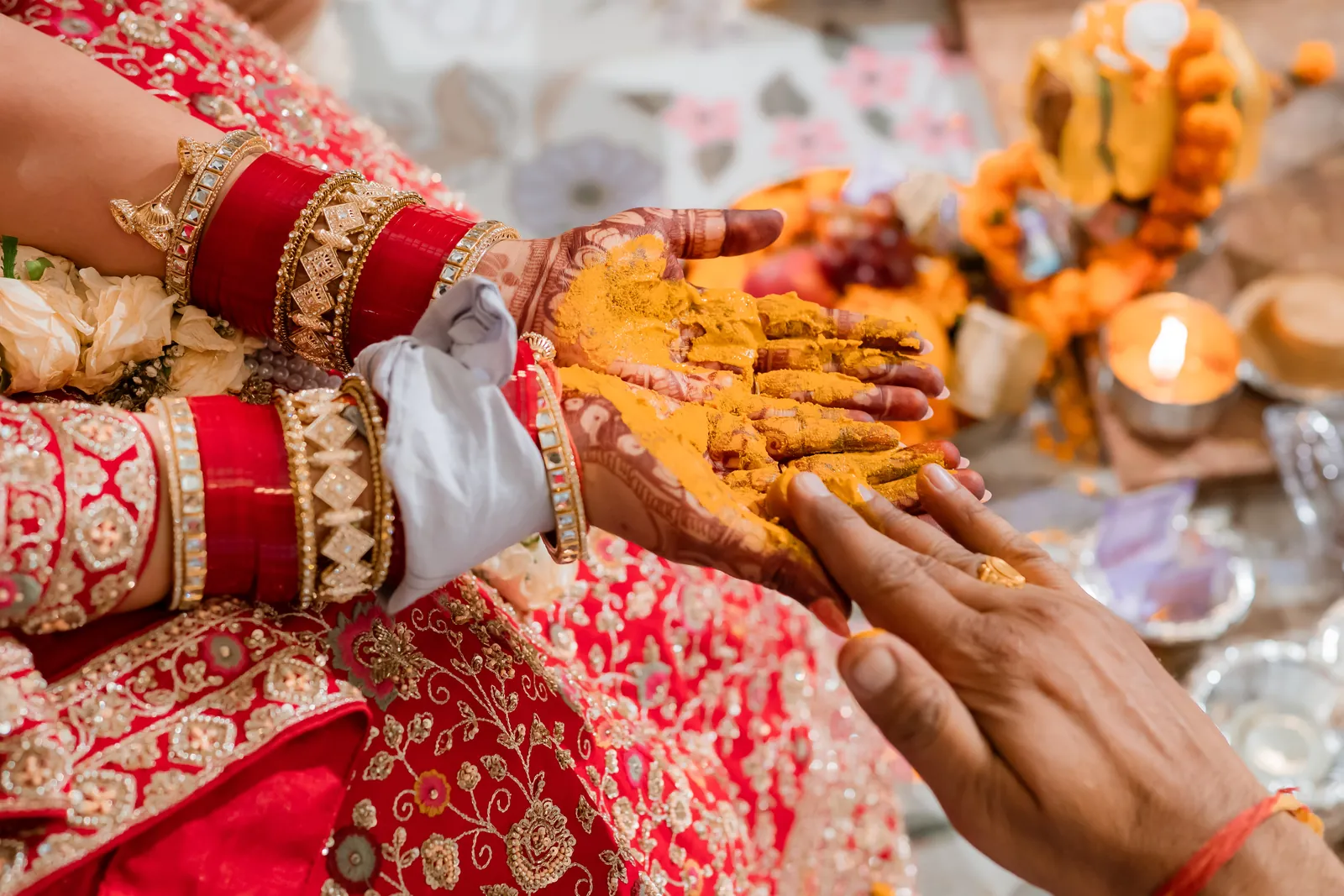 Turmeric-covered hands of the bride during the haldi ceremony
